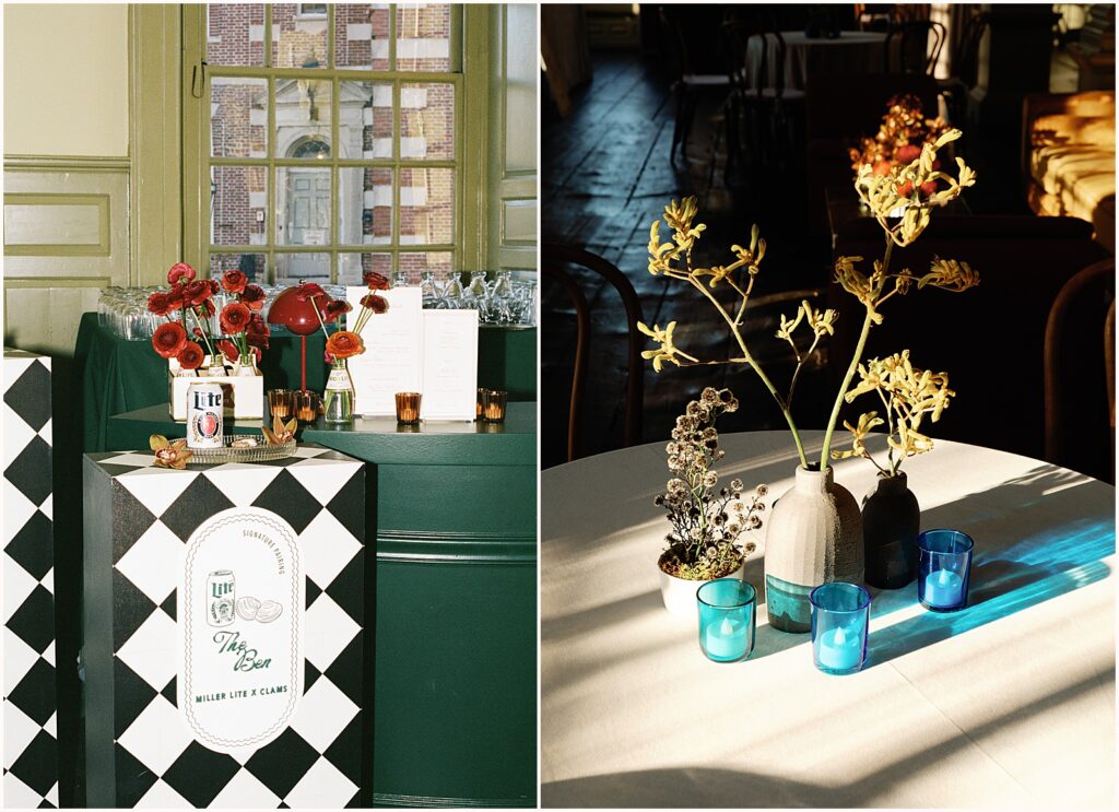 Blue candleholders and red flowers sit on a wedding reception table inside Colony House Newport.