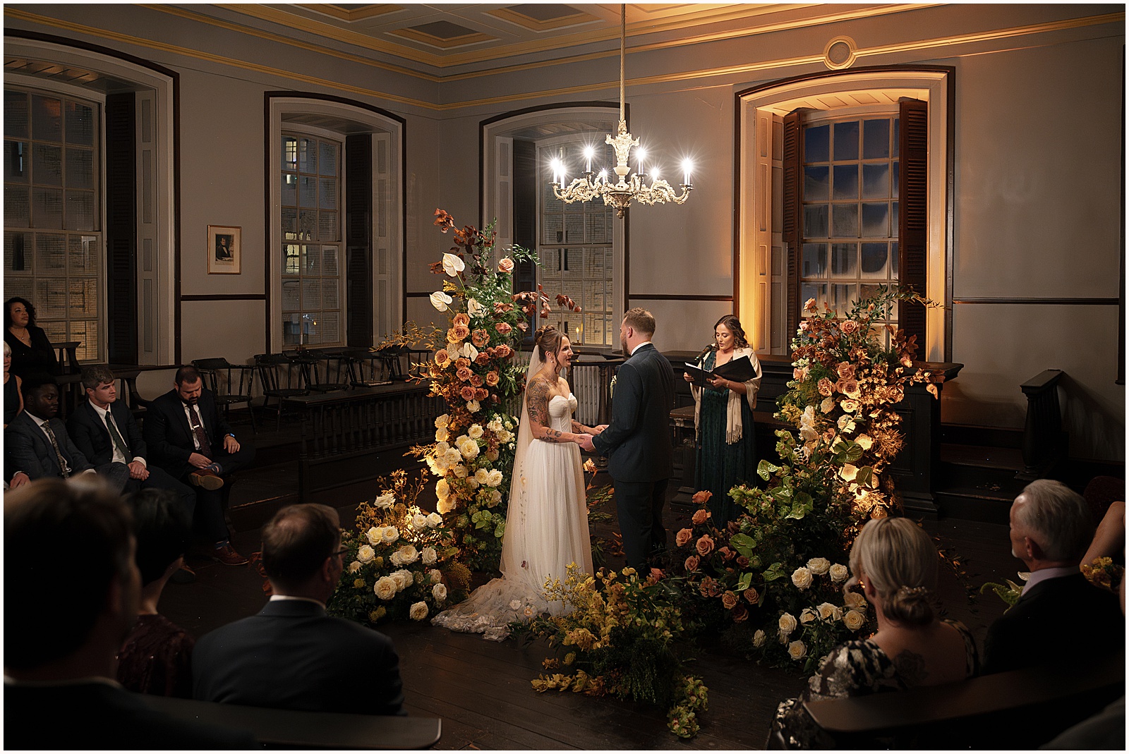 A bride and groom hold hands during a wedding ceremony at Colony House Newport.