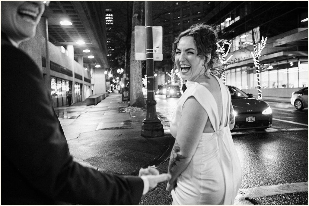 A bride leads her spouse down a Portland street after their elopement.