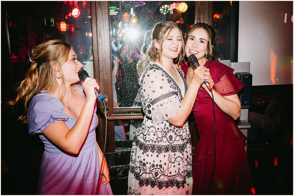 A bride sings karaoke with friends at a Portland wedding reception.