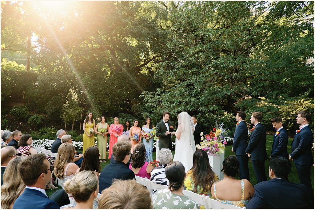 Wedding guests watch an outdoor wedding ceremony at a Portland wedding venue.